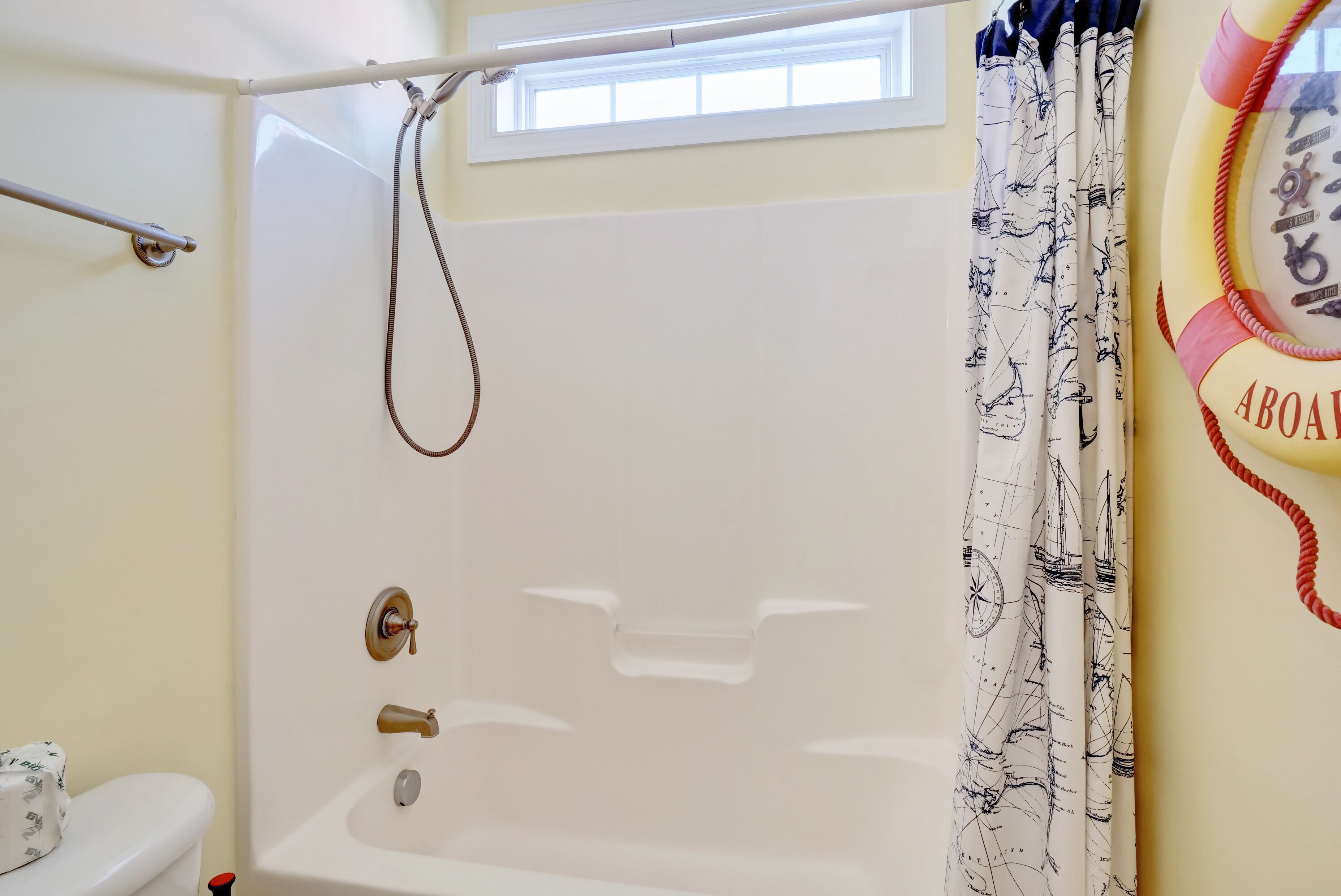 A bathroom with a bathtub, a toilet, and a window.