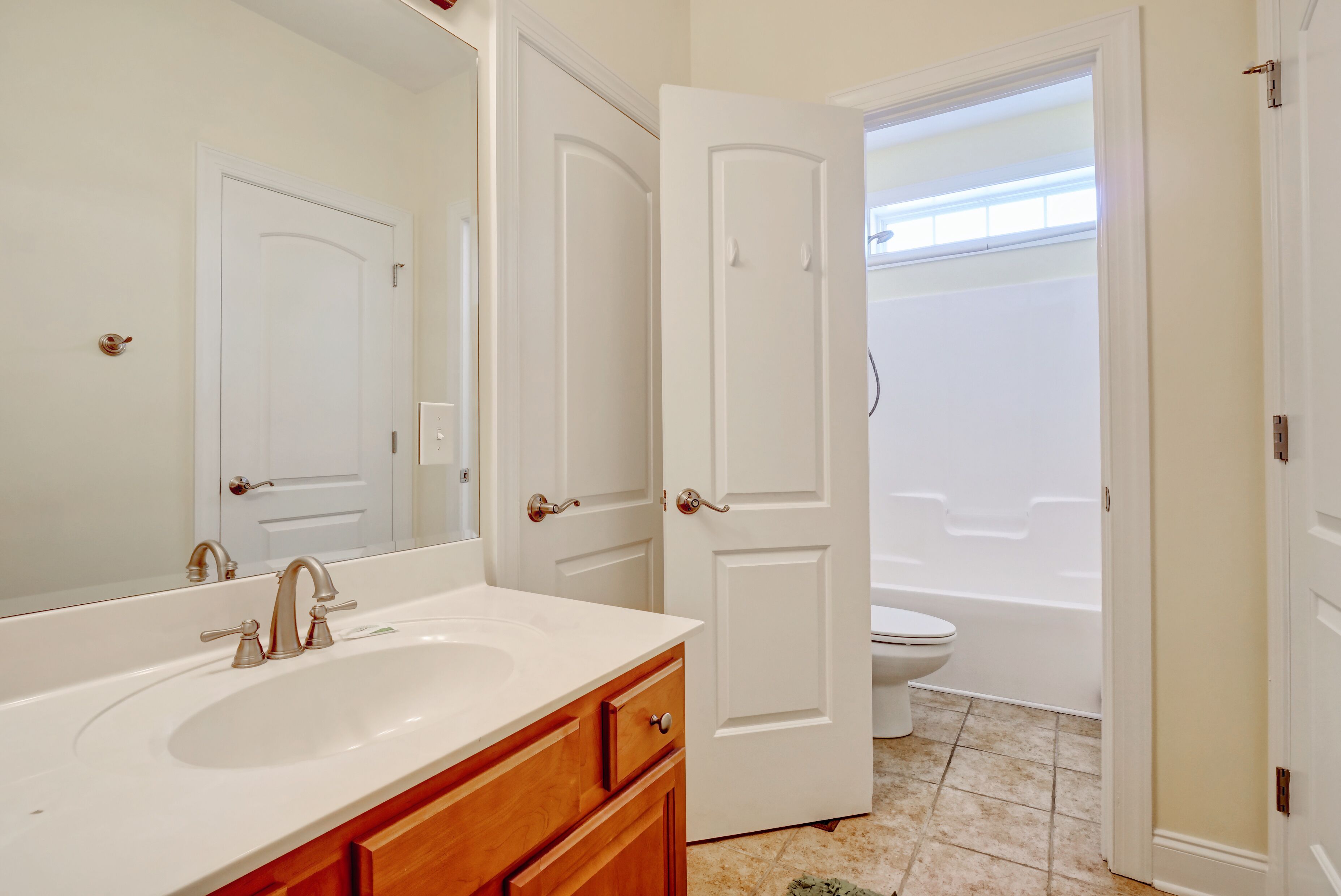 A bathroom with a sink, mirror, and toilet.
