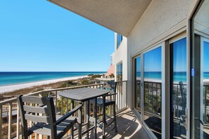 Enjoy stunning ocean views from this balcony with a table and two chairs.