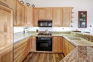 Kitchen features a microwave, gas stove, and dishwasher, along with a single sink and stainless steel faucet.