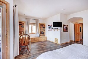 Relax in this serene bedroom with a large bed, a cozy reading nook, and a flat-screen TV.