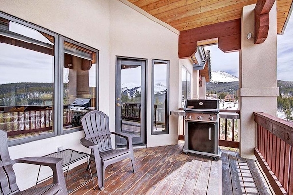 Enjoy al fresco dining with a mountain view from this outdoor space featuring a deck, barbecue grills, and comfortable seating.
