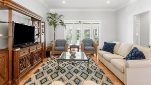 A living room with a TV, two armchairs, a sofa, a coffee table, and a patterned rug. - SHORT WALK TO BEACH!! PRIVATE POOL! (Destin)