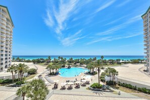 A resort with a central swimming pool, palm trees, and a view of the ocean. - Updated, modern, beachfront condo w/private balcony! 🌴 (Destin)