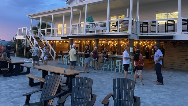Eine Strandbar mit Außenbereich und überdachter Terrasse.