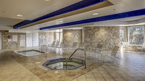 Ein Poolbereich mit mehreren Pools, Liegestühlen und Sicherheitsschildern.