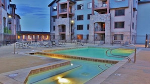 Area piscina con lettini e un edificio sullo sfondo.