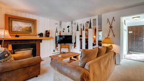 A living room with a fireplace, sofa, television, and decorative items. - Adorable Condo, Walking Distance To Everything. Including Pool/Hot Tub IC4 (Breckenridge)