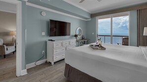 Ein Schlafzimmer mit einem großen Bett, einem Fernseher, einem Deckenventilator und Meerblick.
