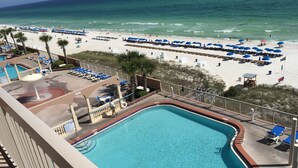 Ein Poolbereich mit Blick auf den Strand und den Ozean.