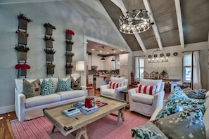 A spacious living room with a high ceiling, a wooden coffee table, and a sofa set. - Watercolor - Rudy's Rendezvous by Coastal Dreamin (Santa Rosa Beach)