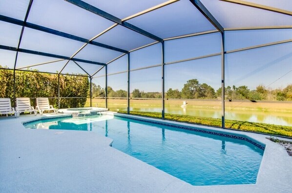 Relax by the pool surrounded by lush greenery and a tranquil landscape.