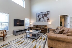 Relax in this stylish living room with a flat-screen TV, comfortable sofa, and a glass coffee table.