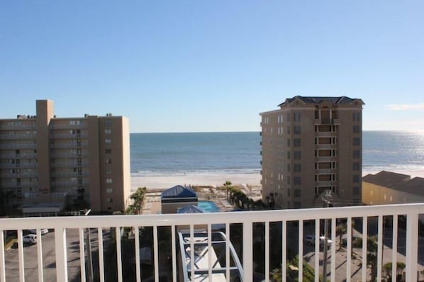 A high-rise hotel overlooking a beach with a clear view of the ocean.