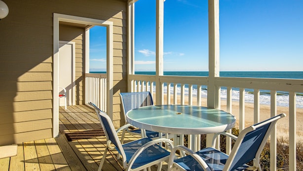 A covered outdoor area with a table and chairs, overlooking a beach. - 3 NIGHT MINIMUM SUMMER SPECIAL!!! GREAT FOR GUEST WHO CAN'T STAY A WEEK!!! (Pine Knoll Shores)