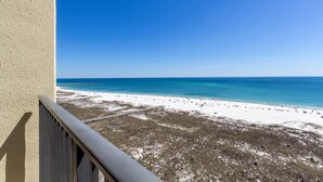 A balcony with a view of a beach and ocean.