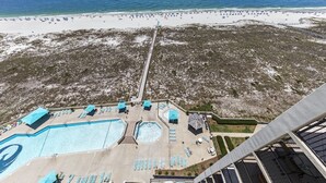 Un complex turístic amb una àrea de piscina gran, accés a la platja i vistes a l'oceà.