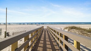 A wooden boardwalk leading to a sandy beach with clear skies. - Broadmoor 901 by Liquid Life (Orange Beach)