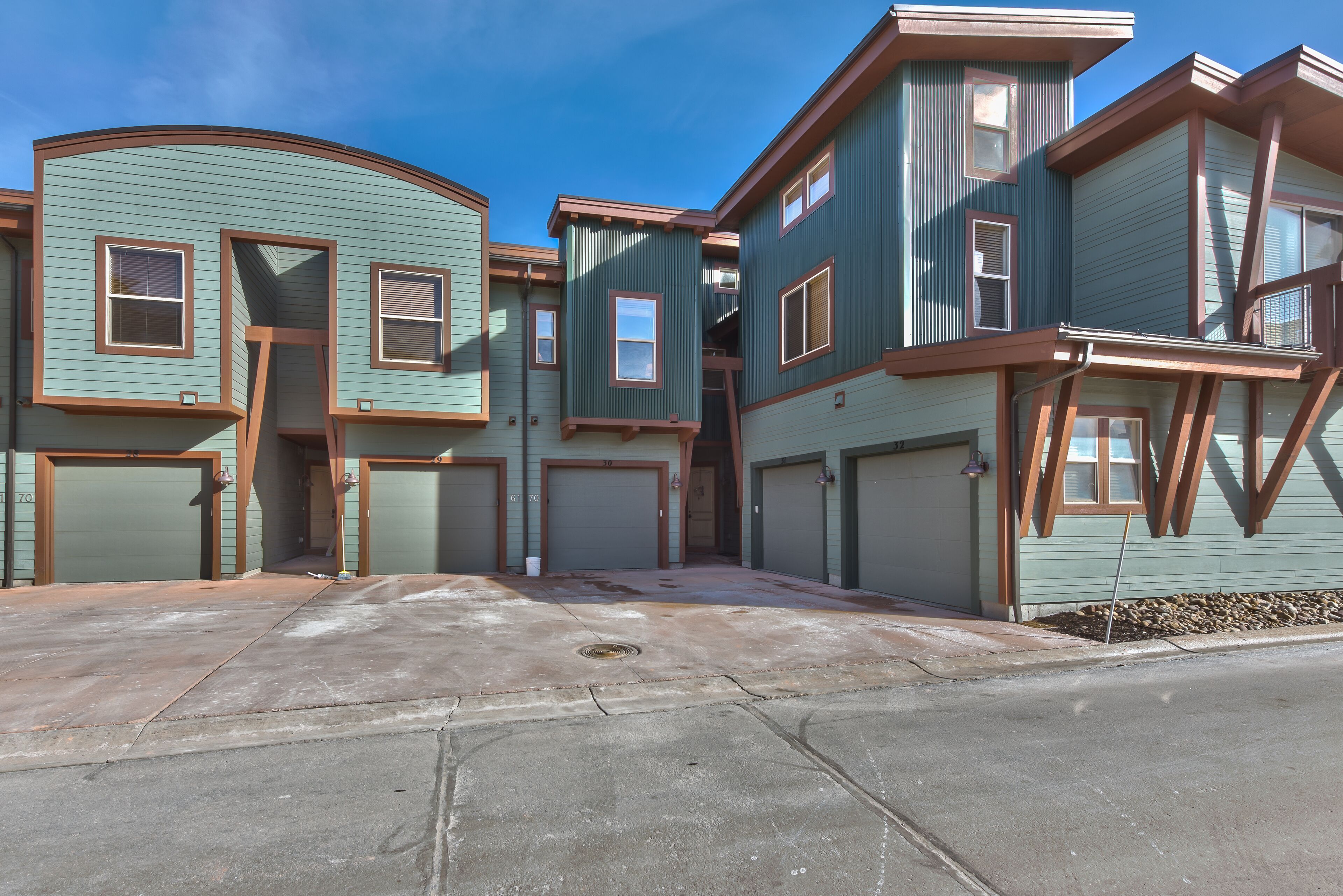A row of townhouses with attached garages and a curved driveway.