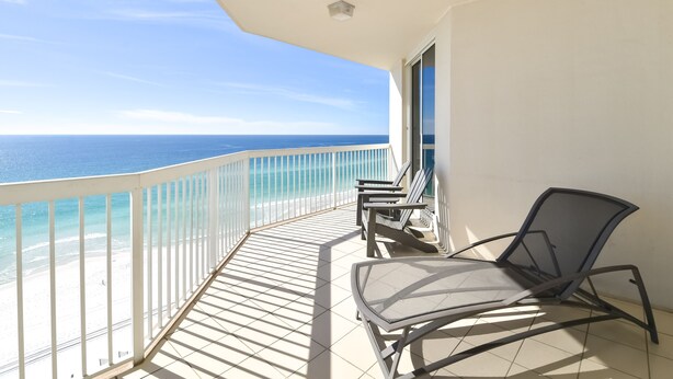 A balcony with a view of the ocean, a chair, and a table. - 4 BR Gulf-Front Condo | Silver Beach Towers E 1101 | Sleeps 10| Book Now! (Destin)