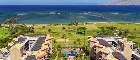 A resort with multiple buildings, a swimming pool, and a view of the ocean.