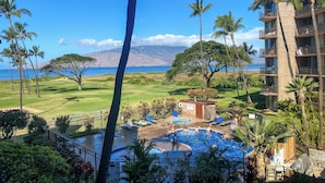 A resort with a pool area, palm trees, and a view of the ocean. - Kauhale Makai #330 Oceanfront, Pool, Hot tub, A/C, Wi-Fi, Stunning Sunsets! (Kihei)