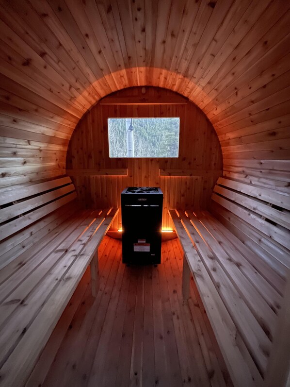Una sauna con paredes de madera y un banco.