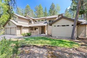 A two-story house with a garage, a covered front porch, and a landscaped yard. - 1 Colonial- Primary Suites, Hot Tub, SHARC, A/C, Steps to Village & SHARC! (Sunriver)