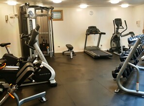 A gym with various exercise equipment including treadmills, a stationary bike, and weight machines.