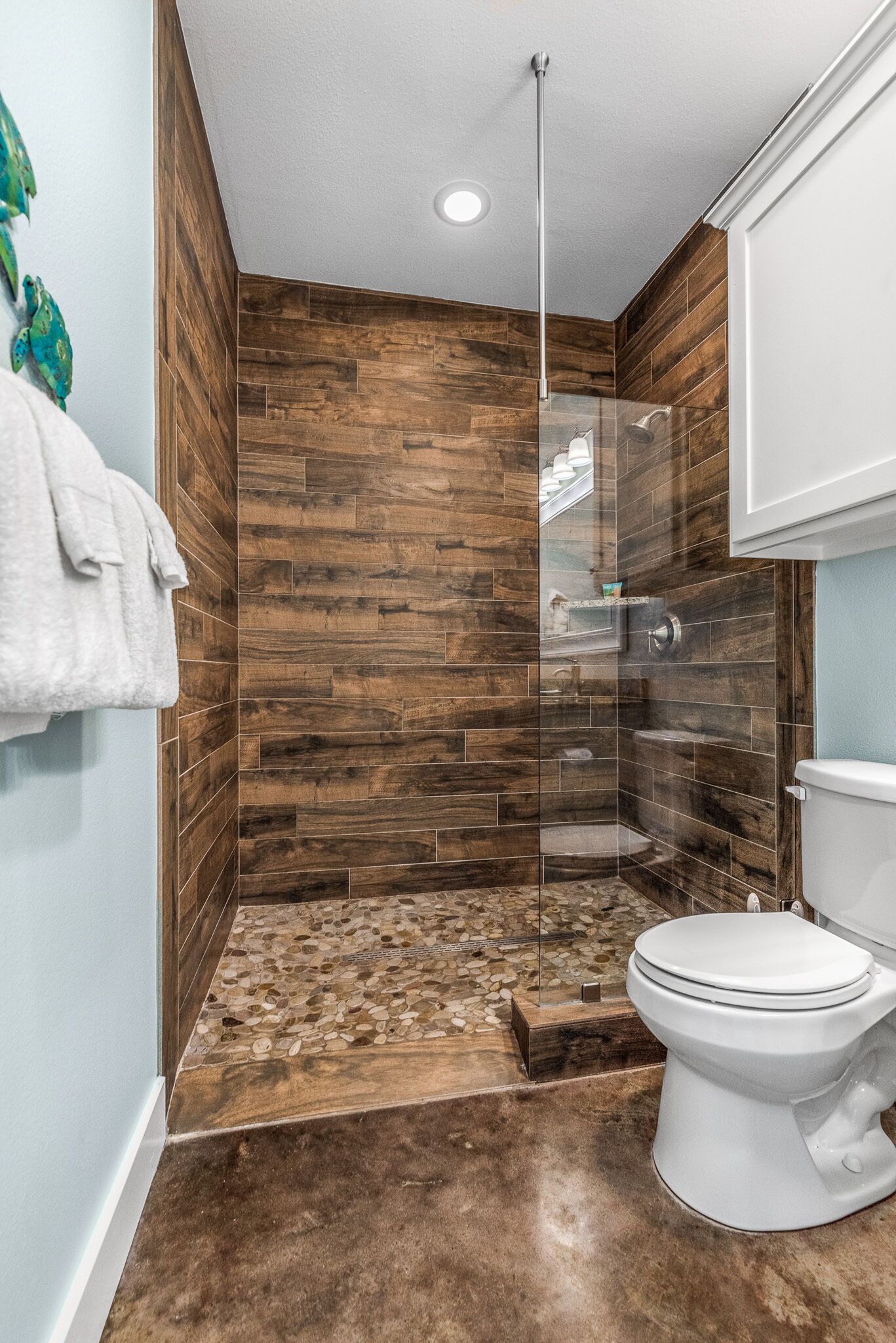Une salle de bain moderne avec une douche, des toilettes et un mur décoré avec du bois.