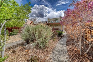 Stroll through the beautifully maintained garden, leading to a modern house with a flat roof and a spacious balcony.