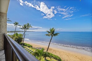 A beach view with palm trees and a clear sky. - Kihei Beach #406 – Panoramic Ocean Views and Relaxed Luxury (Kihei)