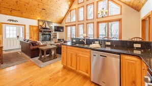 A spacious kitchen with wooden cabinets, a dishwasher, and a large window. - Dog Friendly Retreat w/ Indoor Pool, Hot Tub & Spa (Mchenry)