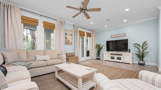 A living room with a beige sofa, a coffee table, a TV, and a ceiling fan. - Best of Gulf Place at Your Doorstep Heated pools/Walk to Shops/Restaurants (Santa Rosa Beach)