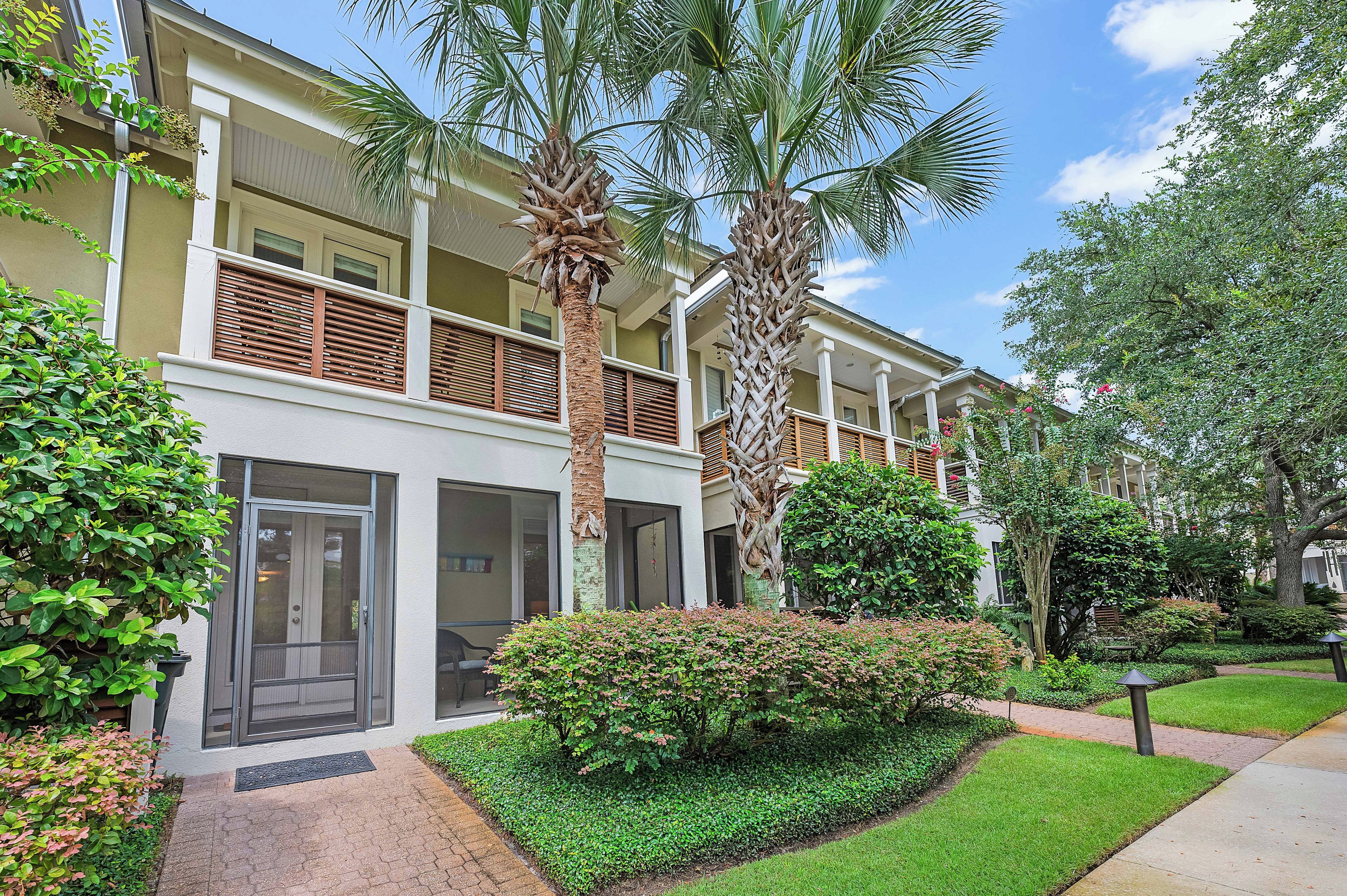 A multi-story hotel with balconies, palm trees, and well-maintained landscaping.