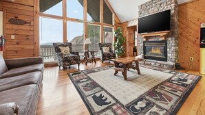A spacious living room with a fireplace, large windows, and a cozy seating area.