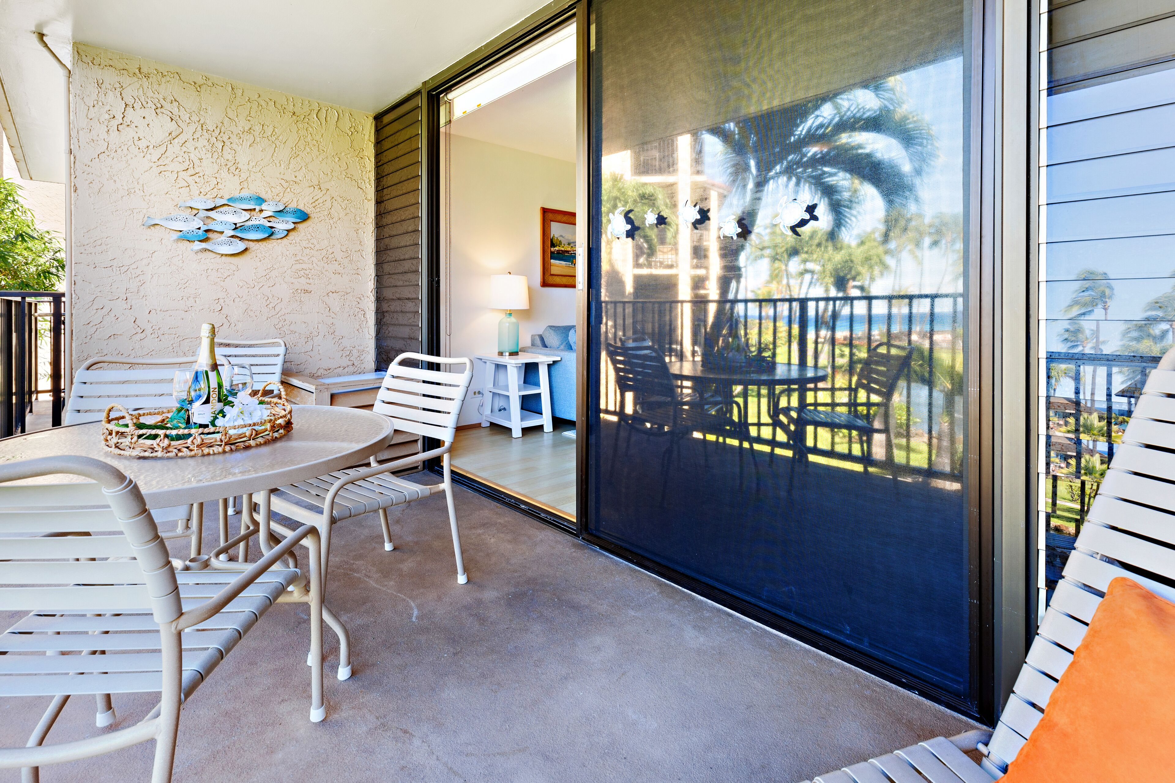 Un balcone con tavolo e sedie, un muro decorativo e vista sull'esterno.