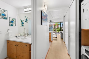 Un baño moderno con tocador de madera, un espejo grande y decoración de peces en la pared.