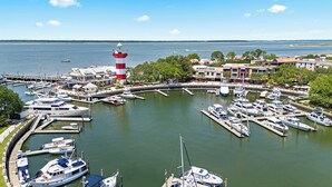 A marina with multiple boats docked, a prominent lighthouse, and surrounding buildings. - Walk to Beach Club, Pet Friendly, Open Plan and Golf View (Hilton Head Island)