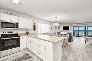 A modern kitchen with white cabinetry, a built-in microwave, and an oven.