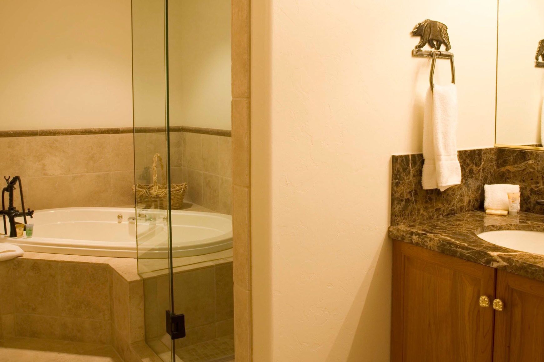 A bathroom with a bathtub, a sink, and a vanity with a mirror.