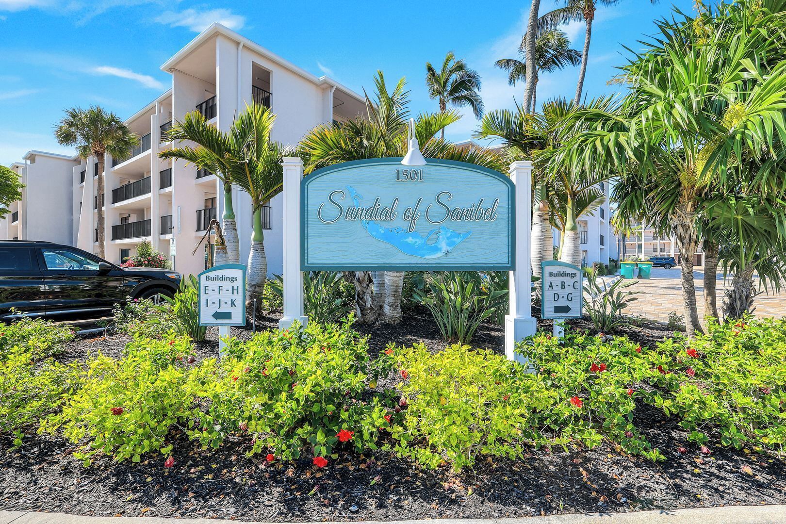 Une enseigne indiquant l’emplacement de « Sundial of Sanibel », offrant une vue dégagée sur les bâtiments environnants et les palmiers.