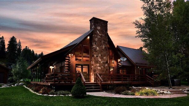 A log cabin with a stone chimney, large windows, and a deck. - Stunning Riverside Cabin, Private Hot Tub, Spacious Yard, Grill (Durango)