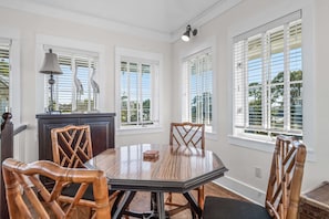 Enjoy meals in this dining room with a large table and six chairs, surrounded by natural light and a stylish cabinet.