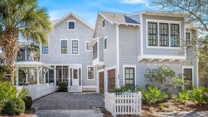 A two-story house with a covered porch, a driveway, and a white picket fence. - Great for Large Groups. 1 Minute to Beach. Private Heated Pool. Carriage House (Watersound)