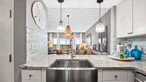 A modern kitchen with a large island, stainless steel sink, and pendant lighting. - Rates Reduced! 2BR Condo with Great Gulf Views! Walk to Beach, Beautiful Pool (Miramar Beach)