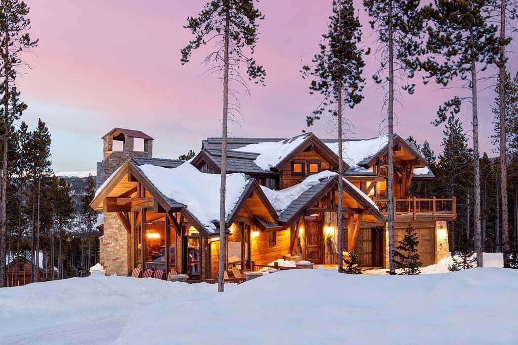 Eine Blockhütte mit mehreren Zimmern, einem Steinkamin und einem Balkon.