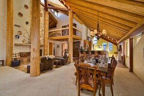 A spacious, multi-level interior with a high ceiling and exposed wooden beams.