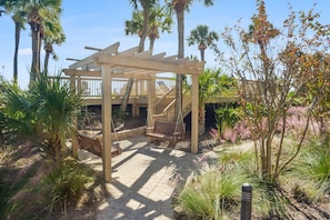 A wooden pergola with a staircase, surrounded by palm trees and various plants. - 2 bedroom/2 bathroom 4th Floor Oceanfront Villa, Sleeps 6, Gets lots of light (Hilton Head)