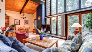 A cozy living room with a fireplace, comfortable seating, and large windows offering a view of the outdoors. - Enchanting Mountain Haven: Ski, Explore & Relax with Unrivaled VIEWS! (Breckenridge)